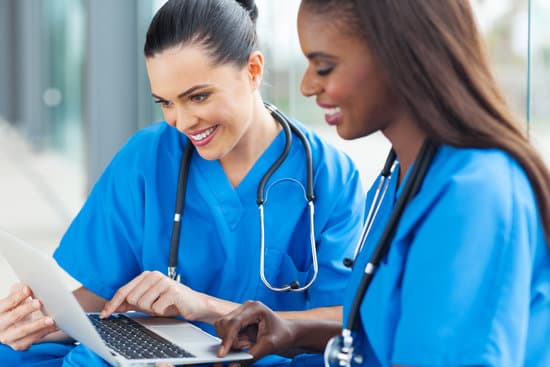 Two nurses working together at a laptop