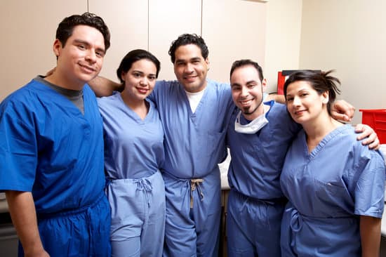 Five smiling members of a clinical team in scrubs